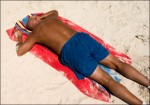 A man sun tanning on the beach